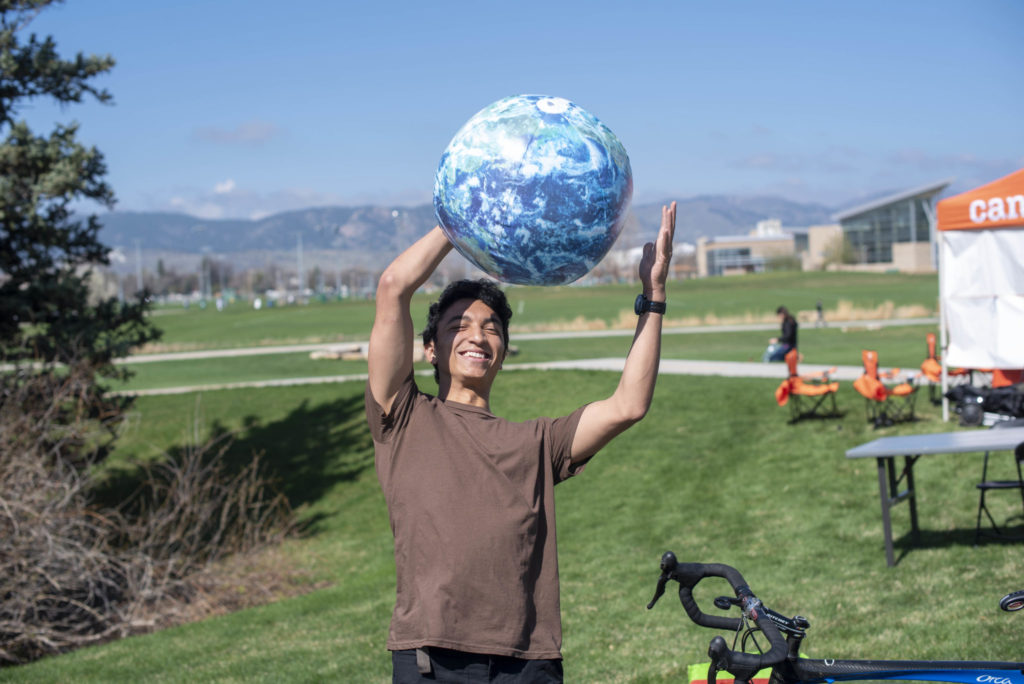 Student throwing Earth-like beach ball